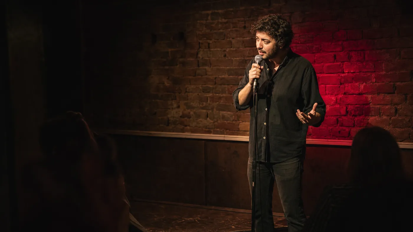 Comediant de stand-up la microfon, sub un reflector