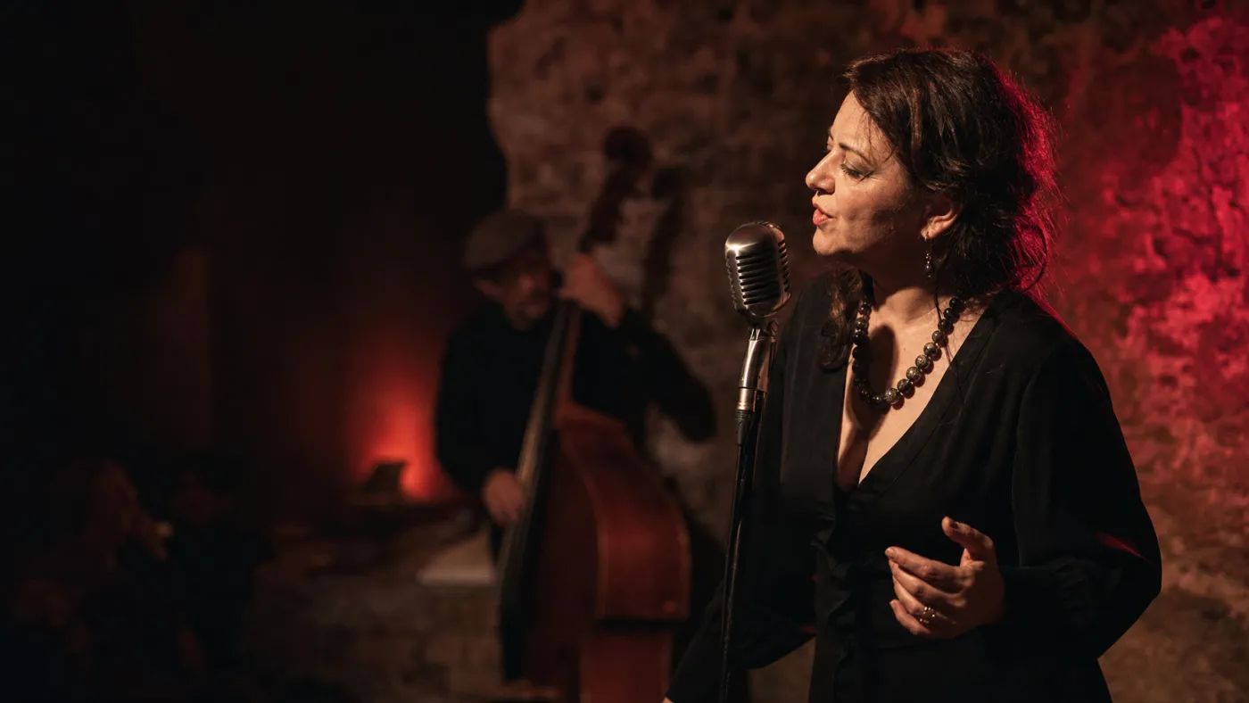Solistă de jazz la microfon, alături de un contrabasist